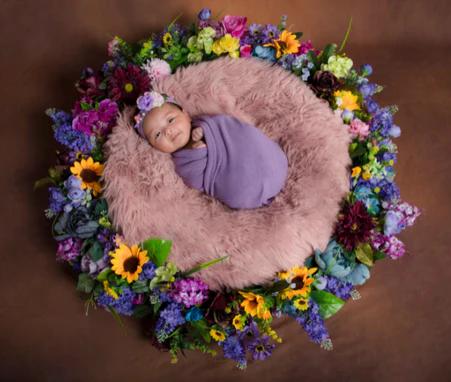 Sweet funny baby with flowers.Cute baby girl with flowers. Children's Day.